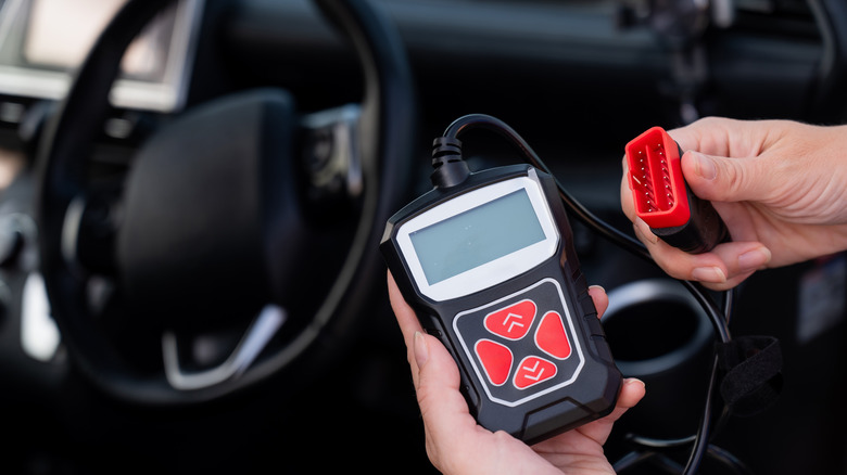 OBD diagnostic scanner connected to vehicle for fault code reading